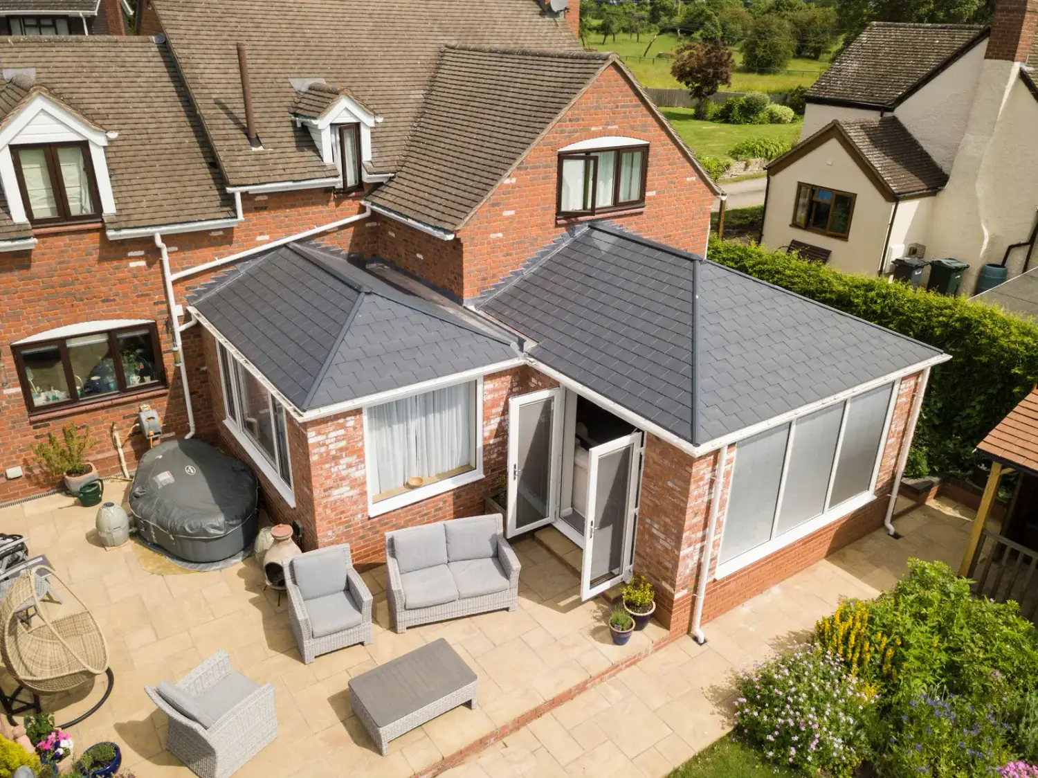 A conservatory fitted with a solid insulated warm roof, seen from the garden